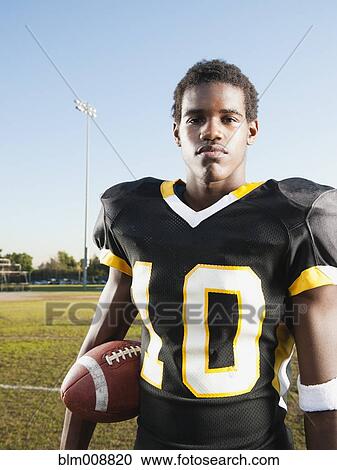 Black football player holding football View Large Photo Image Stock Image - Black football player holding football. Fotosearch