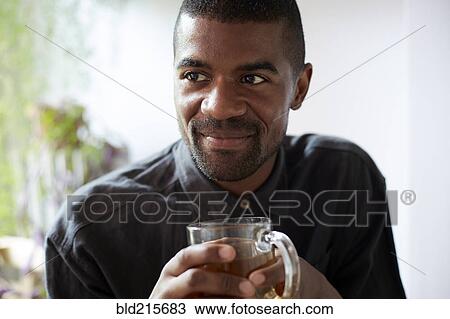 Stock Image - Black man drinking cup of tea. Fotosearch