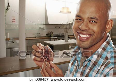 Black man eating ribs in kitchen View Large Photo Image Stock Photo - Black man eating ribs in kitchen. Fotosearch