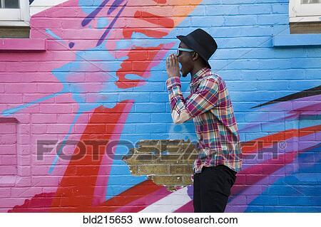 Black man in sunglasses shouting near colorful wall View Large Photo Image Stock Image - Black man in sunglasses shouting near colorful wall. Fotosearch