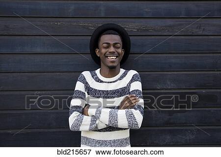 Black man laughing near wooden wall View Large Photo Image Stock Photo - Black man laughing near wooden wall. Fotosearch