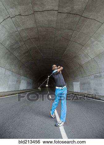 Black man playing golf in urban tunnel View Large Photo Image Stock Photograph - Black man playing golf in urban tunnel. Fotosearch
