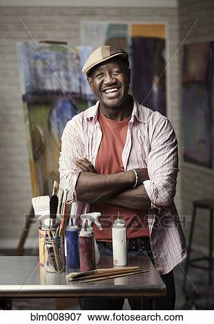 Black man standing in artist's studio View Large Photo Image Stock Photo - Black man standing in artist's studio. Fotosearch