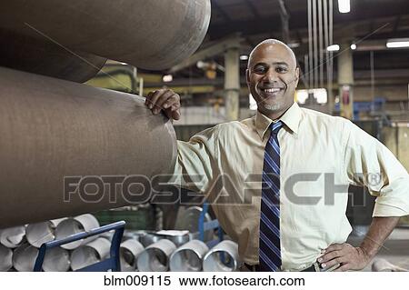 Black manager leaning on metal pipes in factory View Large Photo Image Stock Photography - Black manager leaning on metal pipes in factory. Fotosearch