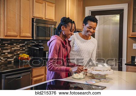 Black mother and daughter decorating cake in kitchen View Large Photo Image Stock Photograph - Black mother and daughter decorating cake in kitchen. Fotosearch