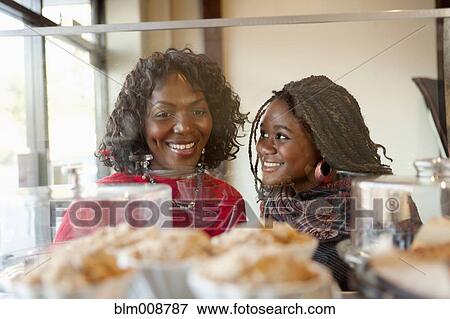 Black mother and daughter looking at pastry in cafe View Large Photo Image Stock Photo - Black mother and daughter looking at pastry in cafe. Fotosearch