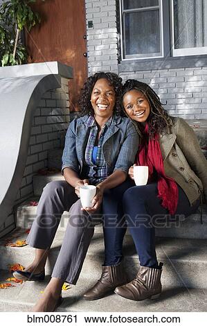 Black mother and daughter sitting on front stoop drinking coffee View Large Photo Image Stock Image - Black mother and daughter sitting on front stoop drinking coffee. Fotosearch