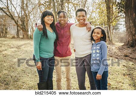 Stock Photography - Black mother and daughters smiling outdoors. Fotosearch