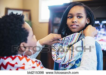 Black mother arranging scarf of daughter View Large Photo Image Stock Photo - Black mother arranging scarf of daughter. Fotosearch