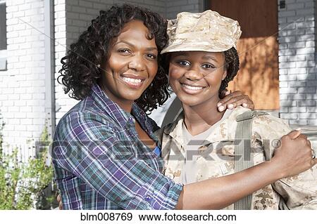 Stock Photo - Black mother hugging soldier daughter. Fotosearch