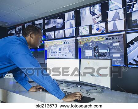 Black security officer watching surveillance cameras View Large Photo Image Stock Image - Black security officer watching surveillance cameras. Fotosearch