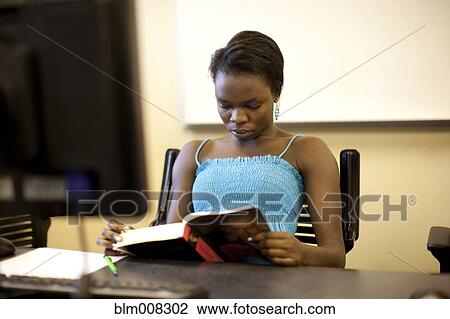 Black student reading book at desk View Large Photo Image Stock Image - Black student reading book at desk. Fotosearch