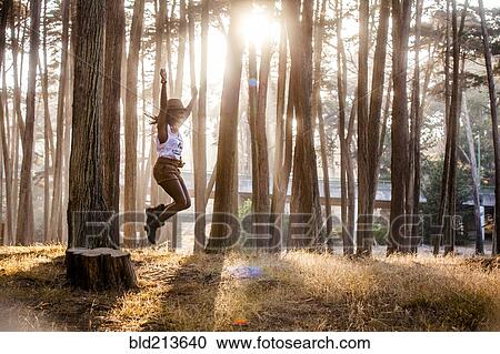 Black woman jumping from stump in sunny forest View Large Photo Image Stock Image - Black woman jumping from stump in sunny forest. Fotosearch