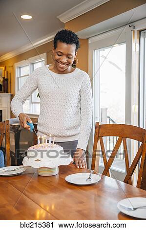 Black woman lighting candles on birthday cake View Large Photo Image Stock Image - Black woman lighting candles on birthday cake. Fotosearch