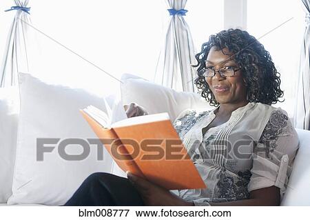 Black woman reading book on sofa View Large Photo Image Stock Photo - Black woman reading book on sofa. Fotosearch