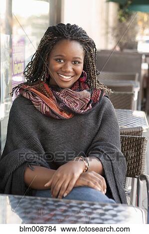 Black woman sitting at outdoor cafe View Large Photo Image Picture - Black woman sitting at outdoor cafe. Fotosearch