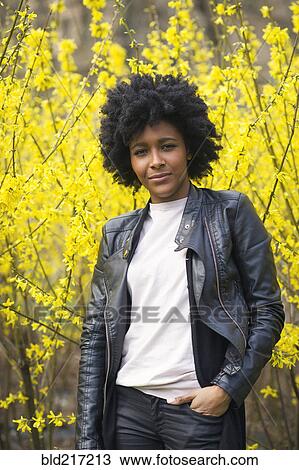 Black woman standing in park under flowering trees View Large Photo Image Stock Image - Black woman standing in park under flowering trees. Fotosearch