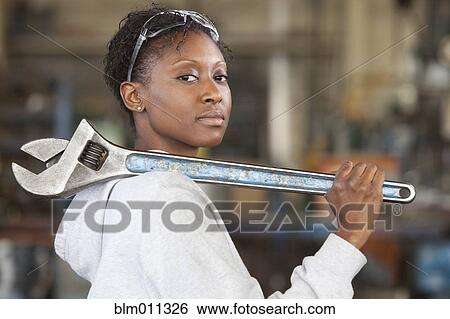 Stock Photograph - Black worker holding large wrench. Fotosearch