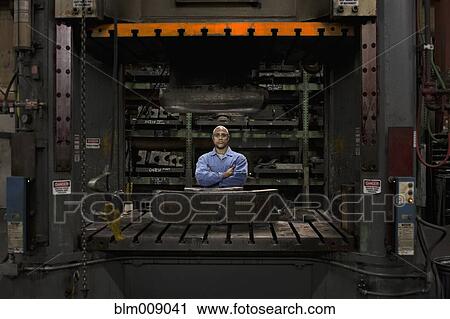 Black worker standing in factory View Large Photo Image Stock Image - Black worker standing in factory. Fotosearch