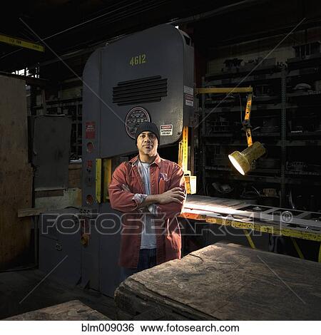 Stock Photograph - Black worker standing in factory. Fotosearch