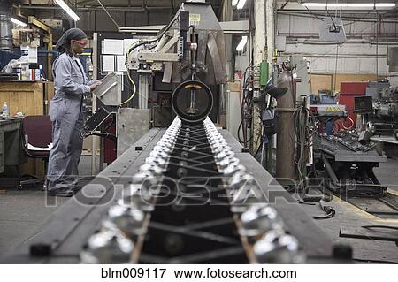 Black worker working on machinery in factory View Large Photo Image Stock Photo - Black worker working on machinery in factory. Fotosearch