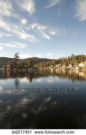 Stock Image - Blue sky and hills reflecting in remote lake. Fotosearch