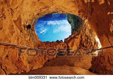 Stock Image - Blue sky through opening in cave. Fotosearch