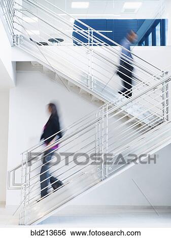 Stock Photograph - Blurred view of business people climbing office staircase. Fotosearch