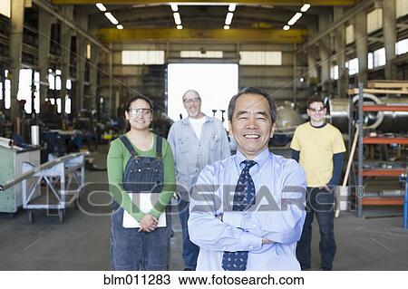 Stock Image - Boss and workers standing in warehouse. Fotosearch