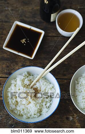 Bowl of rice and chopsticks with sauces View Large Photo Image Stock Photo - Bowl of rice and chopsticks with sauces. Fotosearch