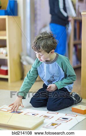 Boy arranging cards on floor in classroom View Large Photo Image Stock Photo - Boy arranging cards on floor in classroom. Fotosearch