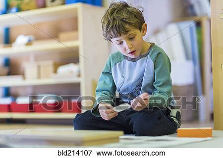 Boy thinking on floor in classroom View Large Photo Image Stock Photo - Boy thinking on floor in classroom. Fotosearch