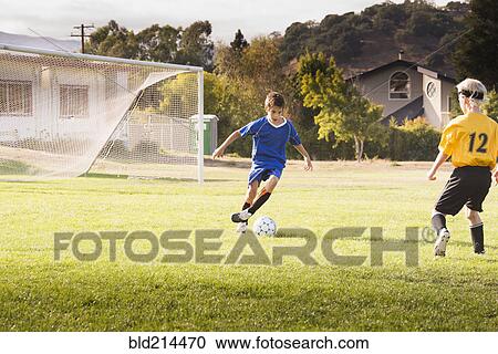 Boys playing soccer on field View Large Photo Image Stock Image - Boys playing soccer on field. Fotosearch