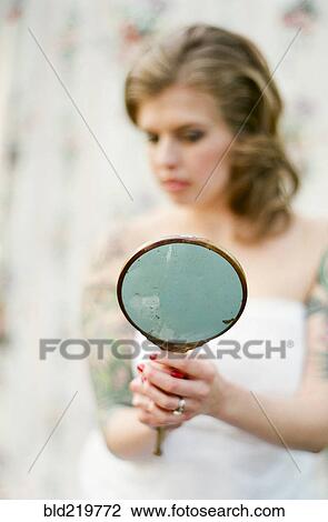Stock Image - Bride admiring herself in mirror. Fotosearch
