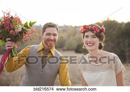 Bride and groom smiling in rural field View Large Photo Image Picture - Bride and groom smiling in rural field. Fotosearch