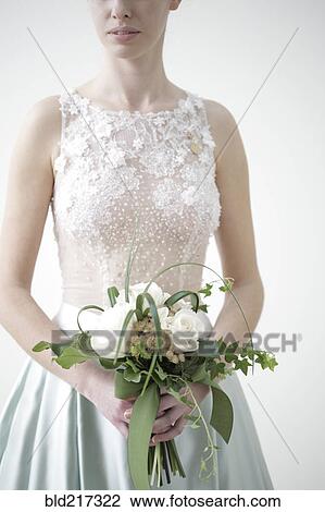 Stock Image - Bride carrying bouquet of flowers. Fotosearch