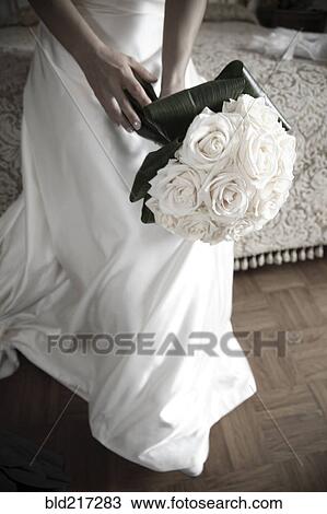 Bride with bouquet sitting on bed View Large Photo Image Stock Image - Bride with bouquet sitting on bed. Fotosearch