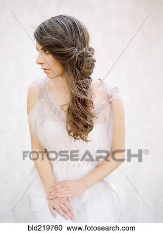 Stock Image - Bride with curled hair in wedding dress. Fotosearch