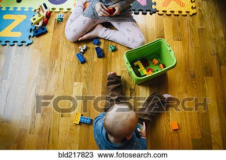 Stock Image - Brother and sister playing on floor. Fotosearch
