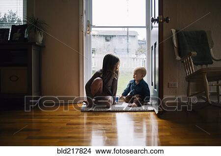 Picture - Brother and sister sitting in doorway. Fotosearch