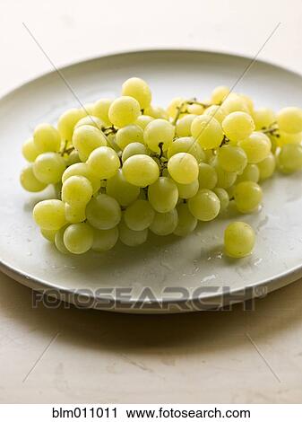 Stock Image - Bunch of green grapes on plate. Fotosearch