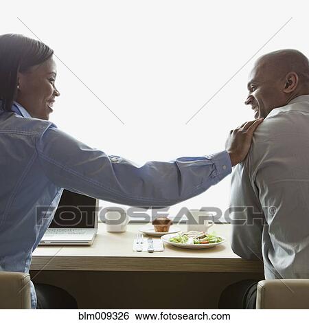 Stock Photograph - Business people eating and working in cafe. Fotosearch