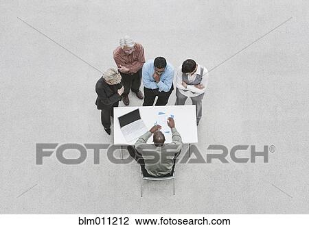Stock Image - Business people in meeting with boss. Fotosearch
