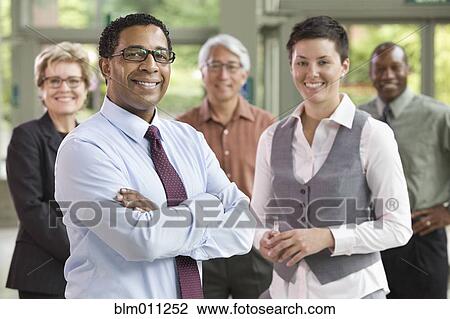 Stock Image - Business people standing together in lobby. Fotosearch
