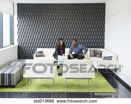 Stock Photograph - Business people talking in office lobby. Fotosearch
