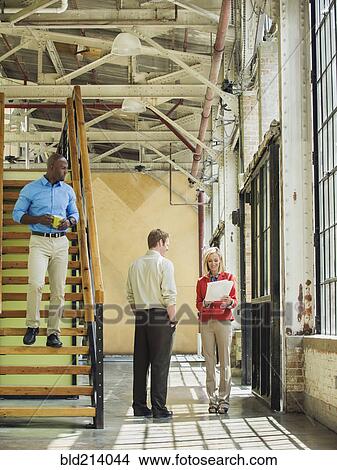 Picture - Business people talking in warehouse. Fotosearch