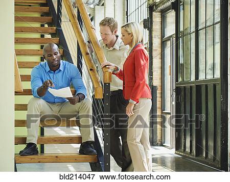 Stock Photo - Business people talking on staircase. Fotosearch