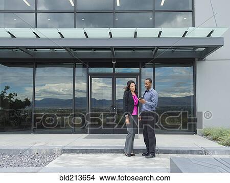 Picture - Business people talking outside office building. Fotosearch