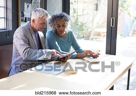 Business people using digital tablet in office meeting View Large Photo Image Stock Photo - Business people using digital tablet in office meeting. Fotosearch