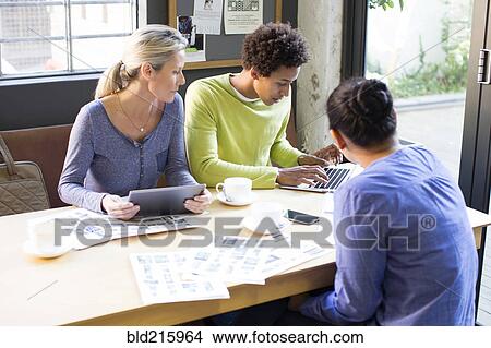 Picture - Business people using technology in office meeting. Fotosearch